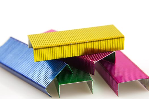 colorful staples in closeup over white background