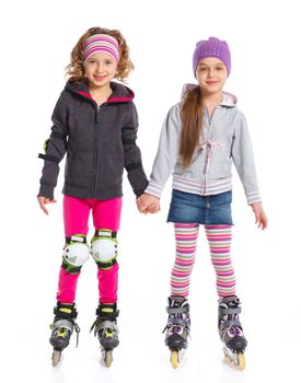 Two cute girls holding hands wearing roller skates. Isolated on a white background