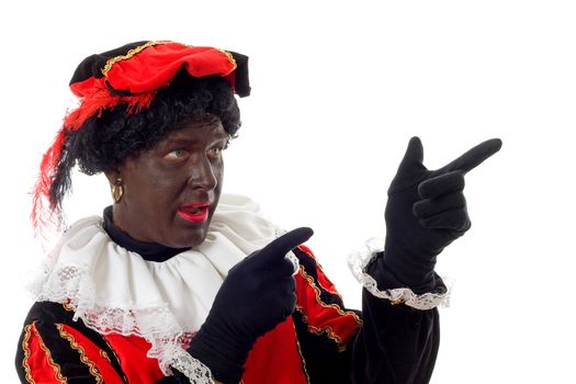Zwarte piet ( black pete) typical Dutch character part of a traditional event celebrating the birthday of  Sinterklaas in december over white background pointing