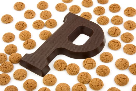 Chocolate letter P and ginger nuts for Sinterklaas, event in the Dutch in december, over white background