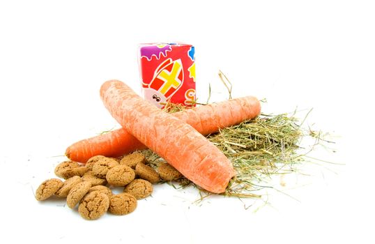 Sinterklaas look with carrots, present, pepernoten and straw over white background