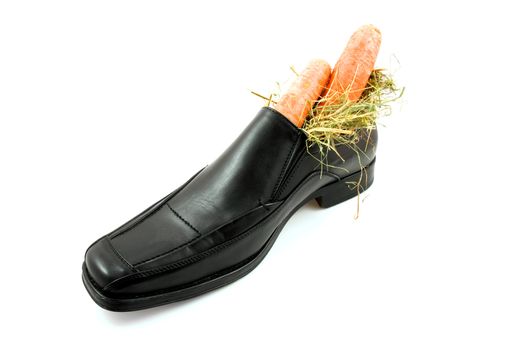 Big black men shoe with carrots for typical Dutch Sinterklaas, over white background