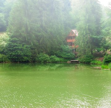 Beautiful wooden house on lake in wood