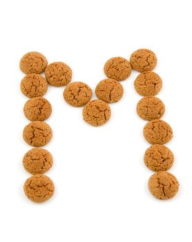 Ginger nuts, pepernoten, in the shape of letter M isolated on white background. Typical Dutch candy for Sinterklaas event in december.