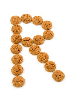Ginger nuts, pepernoten, in the shape of letter R isolated on white background. Typical Dutch candy for Sinterklaas event in december.