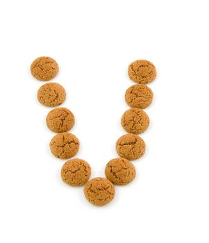 Ginger nuts, pepernoten, in the shape of letter V isolated on white background. Typical Dutch candy for Sinterklaas event in december.