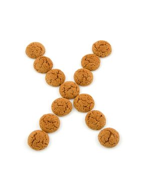 Ginger nuts, pepernoten, in the shape of letter X isolated on white background. Typical Dutch candy for Sinterklaas event in december.