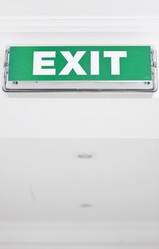 Green exit sign in ceiling. Space for text