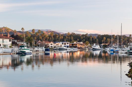 Sunrise at residential development by water in Ventura California with modern homes and yachts boats