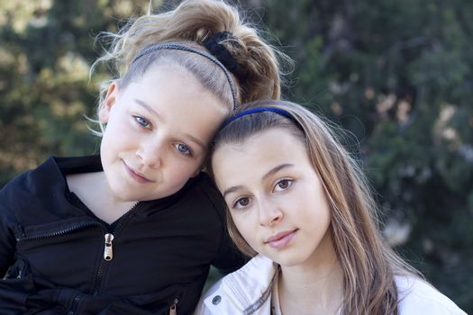 Portrait of two young sisters outside in a park
