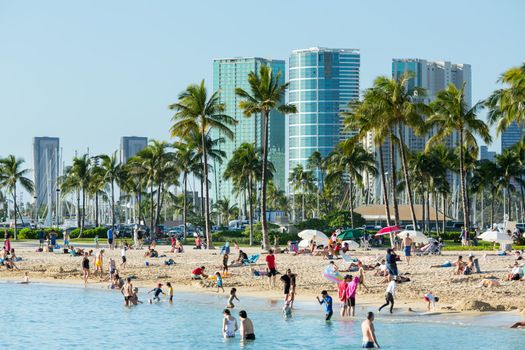 WAIKIKI, HI - JANUARY 20: Tourists sunbathe on busy Hawaii beach on 20 January 2012. The Waikiki Beach restoration project was completed early 2012.