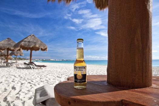 A bottle of Corona (labeled as Coronita in Mexico) on the beautiful white sands of Maroma Beach in Riviera Cancun, Mexico.