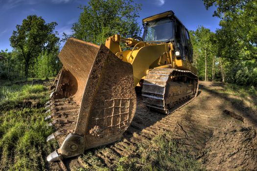 A High Dynamic Range wide angle photo of a bulldozer at a construction site.