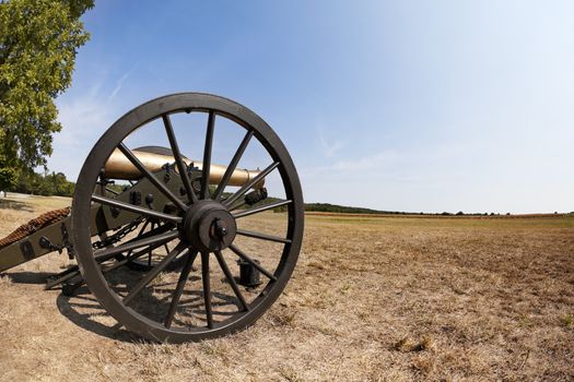 A close up shot of a Civil War cannon in an open field.