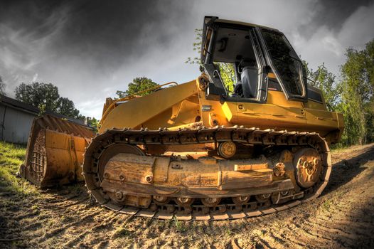 A High Dynamic Range fisheye photo of a bulldozer at a construction site.