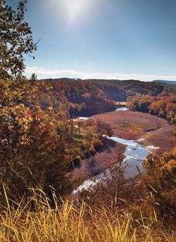 Fall colors in a deep valley with a river flowing through it shot it Arkansas.