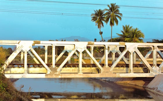 Railway bridge across river in a village outside the city