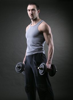 Portrait of muscular man with dumbbells in hand