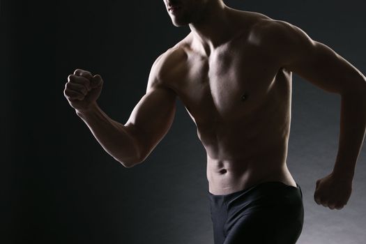 Athletic and muscular man is running