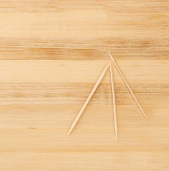 three toothpicks on a light wooden table