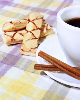 Coffee cup, cinnamon, sweets  on the tablecloth