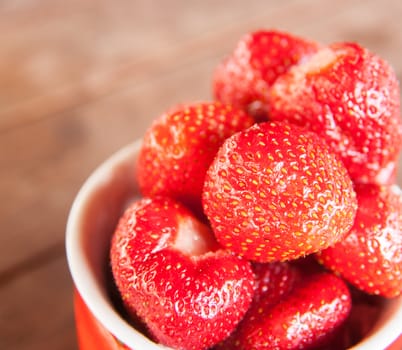 fresh strawberry in the cup on the  wooden table