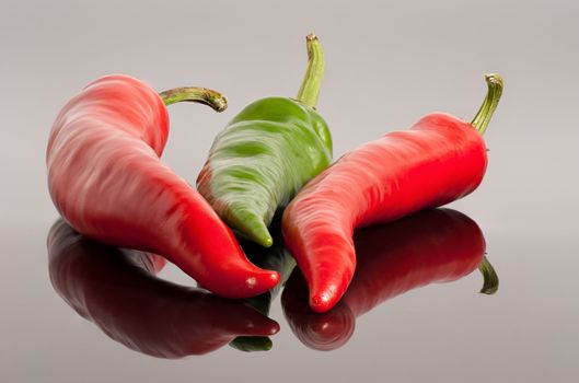 red and green hot chili peppers  background with reflection