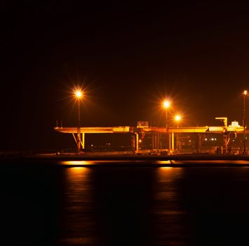 the industrial port at night under floodlights