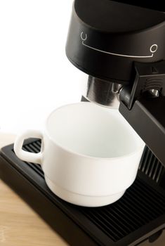 Close up coffee maker machine with white coffee cup