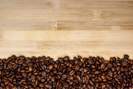 A pile of coffee beans forming a simple stripe frame on a natural background.