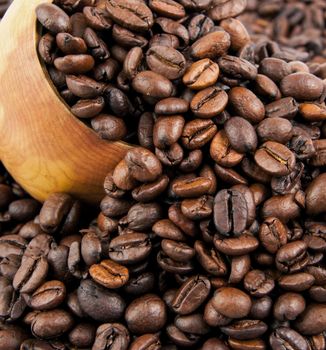 Coffee beans in a wooden spoon and as a background.