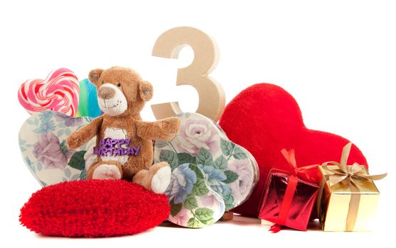 Number of age in a colorful studio setting with heart and gifts and yellow roses