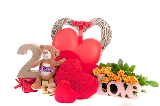 Number of age in a colorful studio setting with heart and gifts and yellow roses