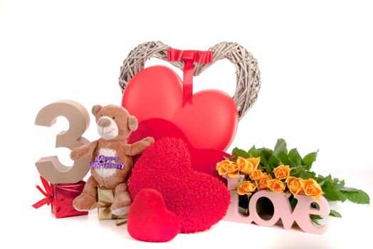 Number of age in a colorful studio setting with heart and gifts and yellow roses