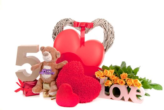 Number of age in a colorful studio setting with heart and gifts and yellow roses