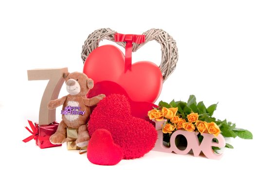 Number of age in a colorful studio setting with heart and gifts and yellow roses