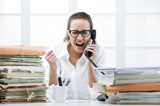 Young business woman shouting to handset phone