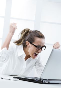Freaked out businesswoman ready to smash her laptop computer 