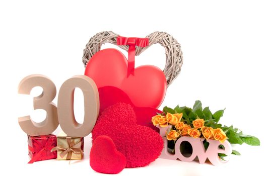 Number of age in a colorful studio setting with heart and gifts and yellow roses