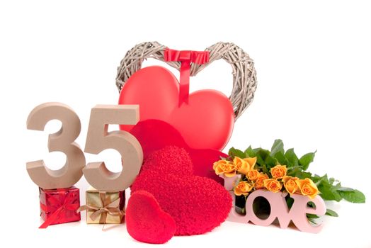 Number of age in a colorful studio setting with heart and gifts and yellow roses