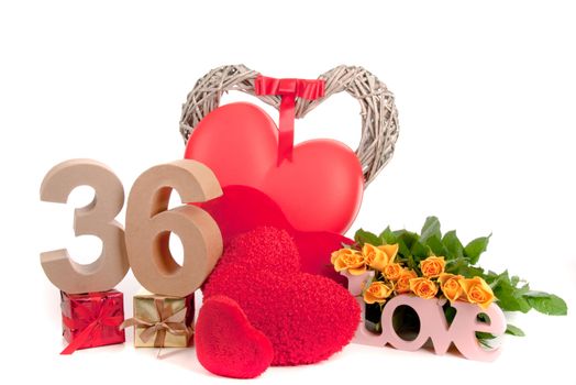 Number of age in a colorful studio setting with heart and gifts and yellow roses