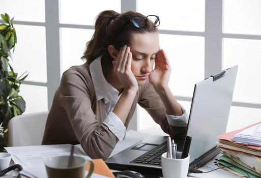 Exhausted businesswoman having a headache.