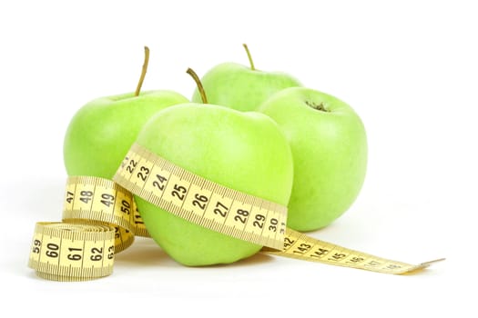 Green apples and yellow measuring tape isolated on white background