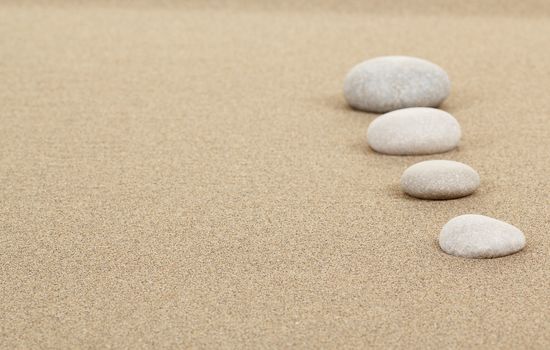 four zen stones in sand as background or backdrop