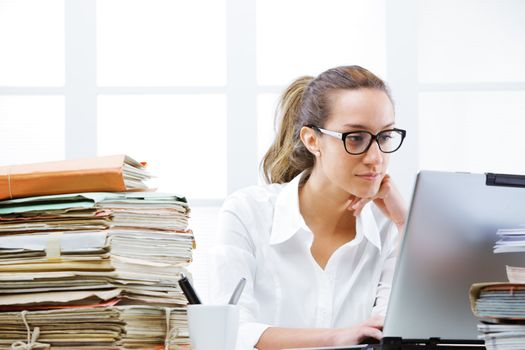 Business woman portrait in an office in front of her laptop