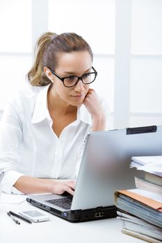 Business woman portrait in an office in front of her laptop