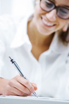 Business woman writing on a document, hand close up