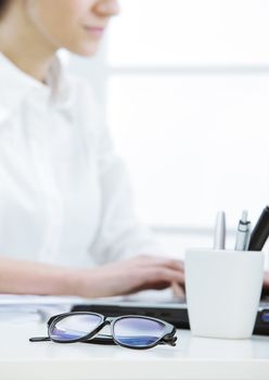 glasses in the foreground and female secretary