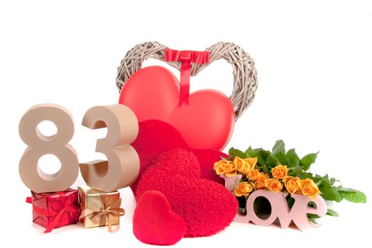 Number of age in a colorful studio setting with heart and gifts and yellow roses