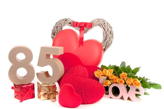 Number of age in a colorful studio setting with heart and gifts and yellow roses